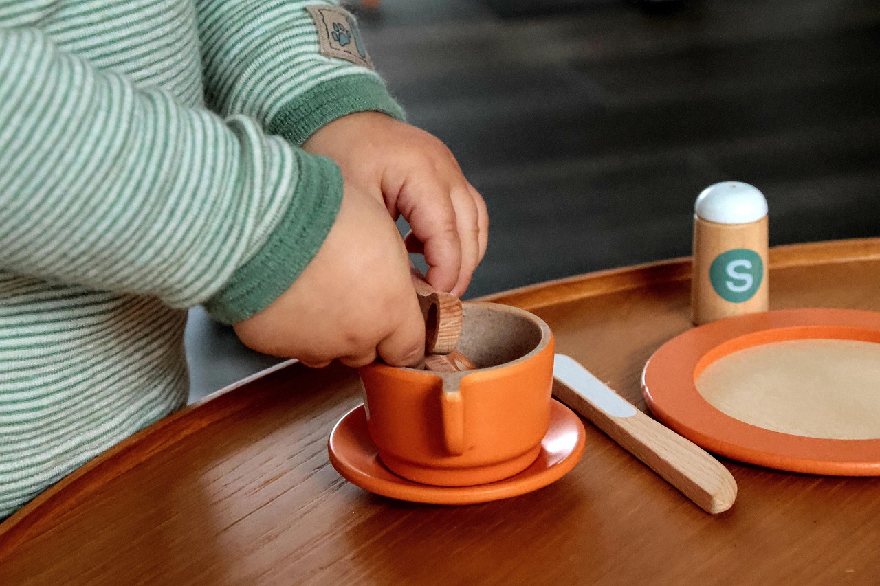 Child's hands, playing with pretend teacup