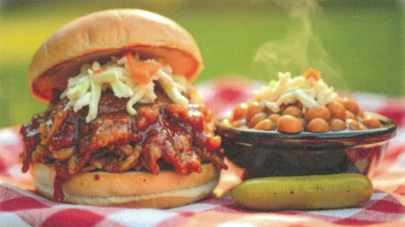 BBQ sandwich and bowel of baked beans with a pickle 