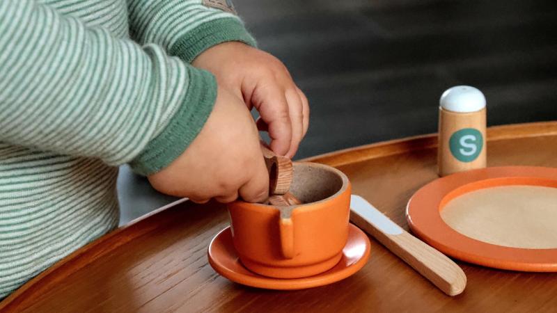 Child's hands, playing with pretend teacup