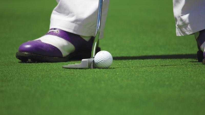 Golfer putting golf ball